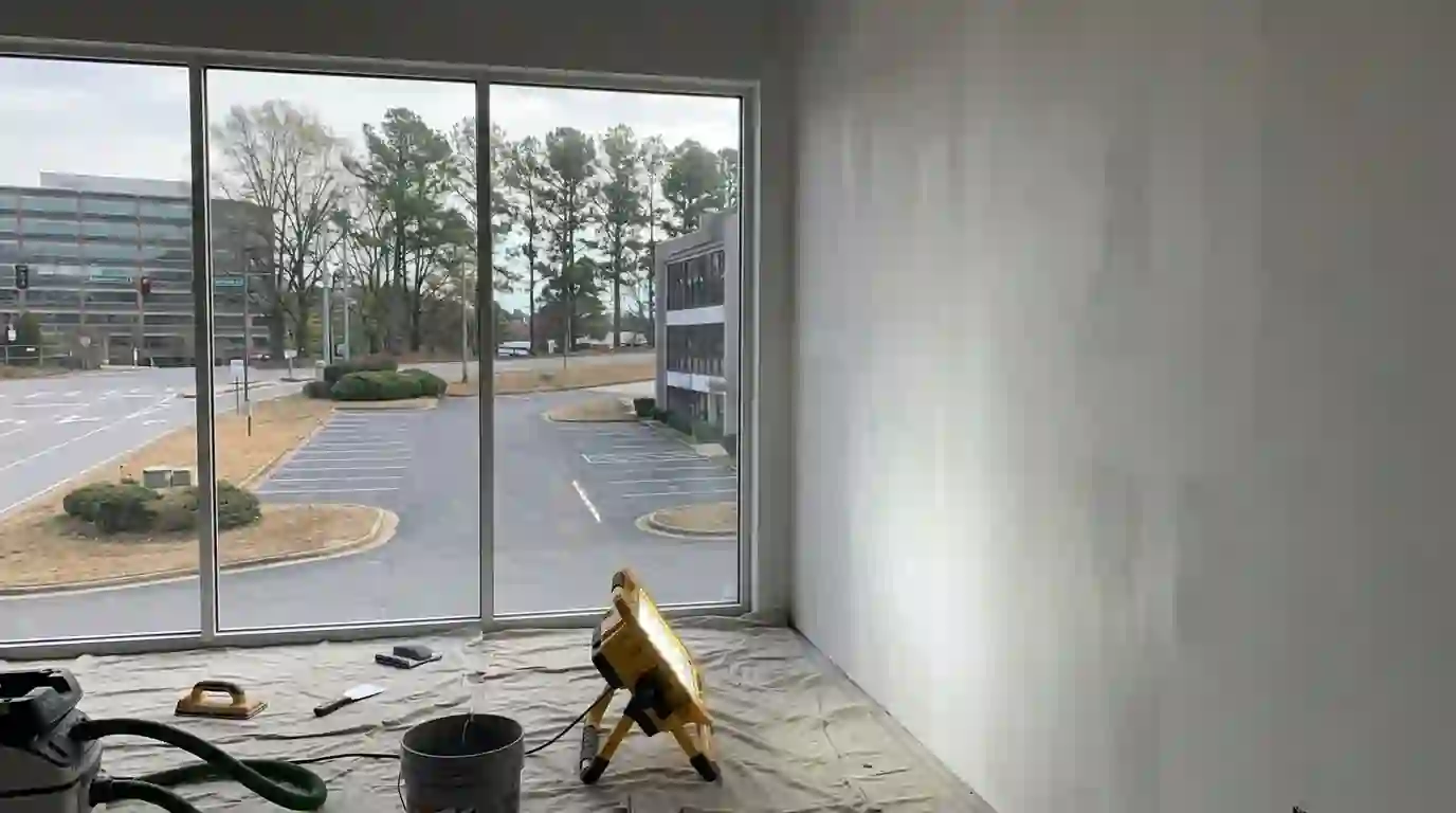 Work light raking across a freshly skimmed wall