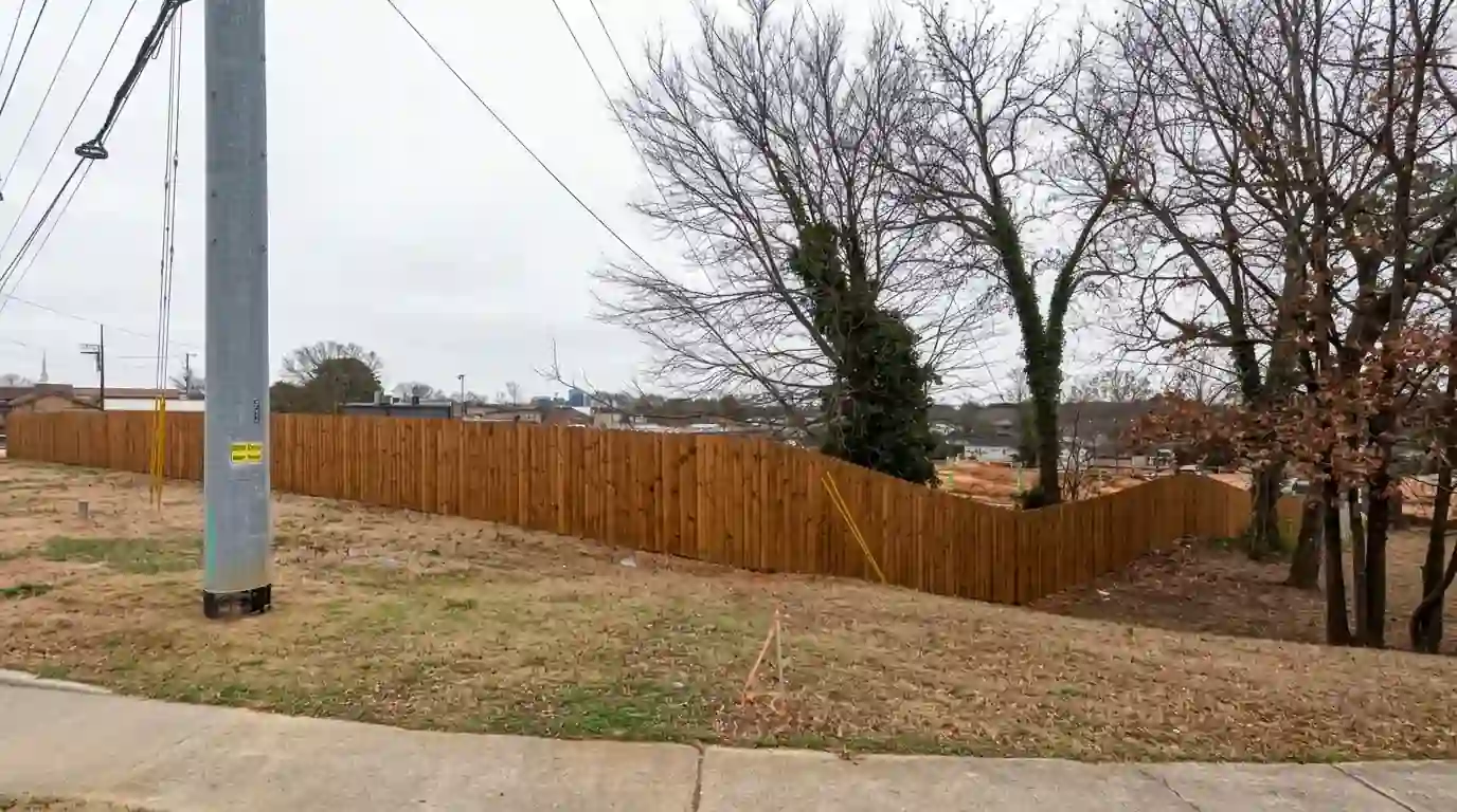 Pine fence stained a warm brown along a back yard