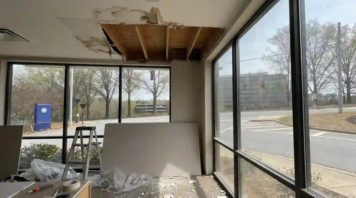 Water-damaged ceiling drywall cut back to the framing