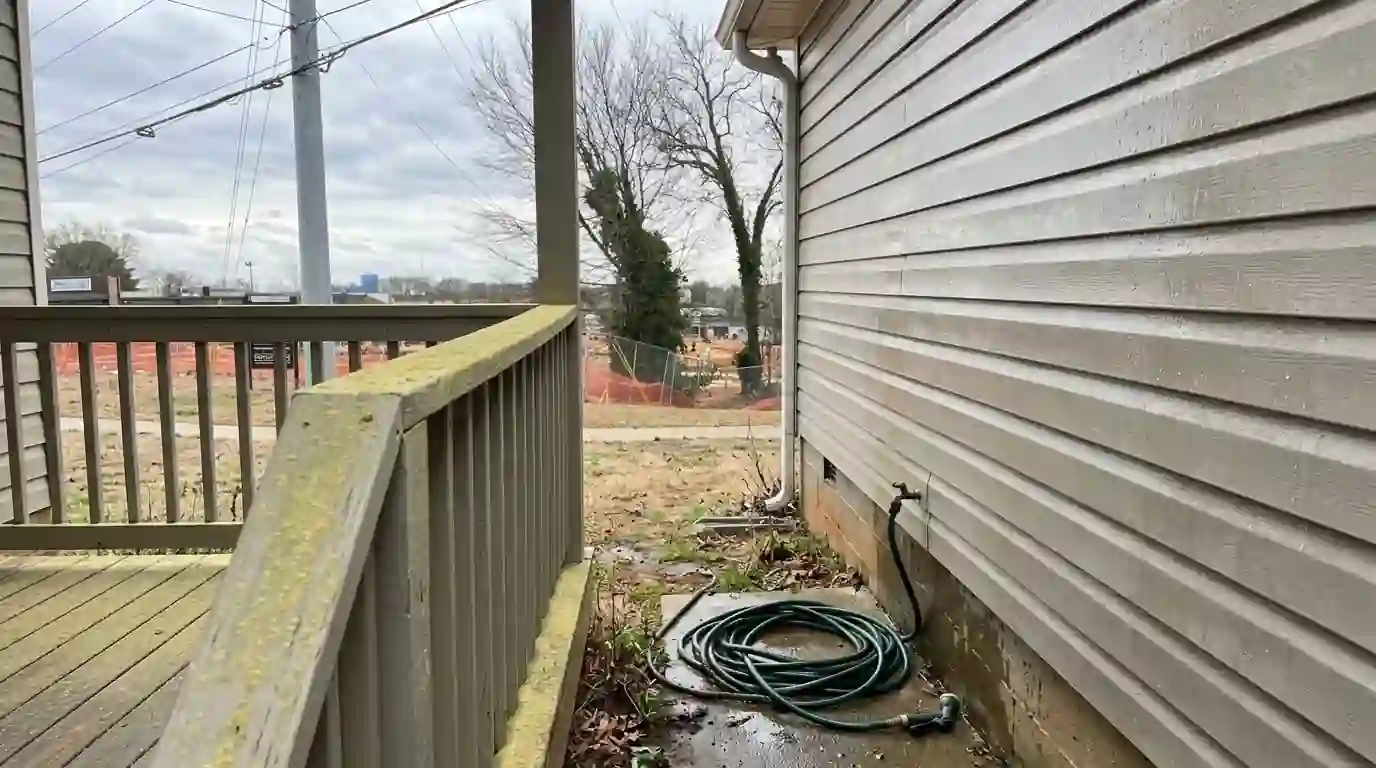 Pine pollen film on a porch rail beside rinsed siding