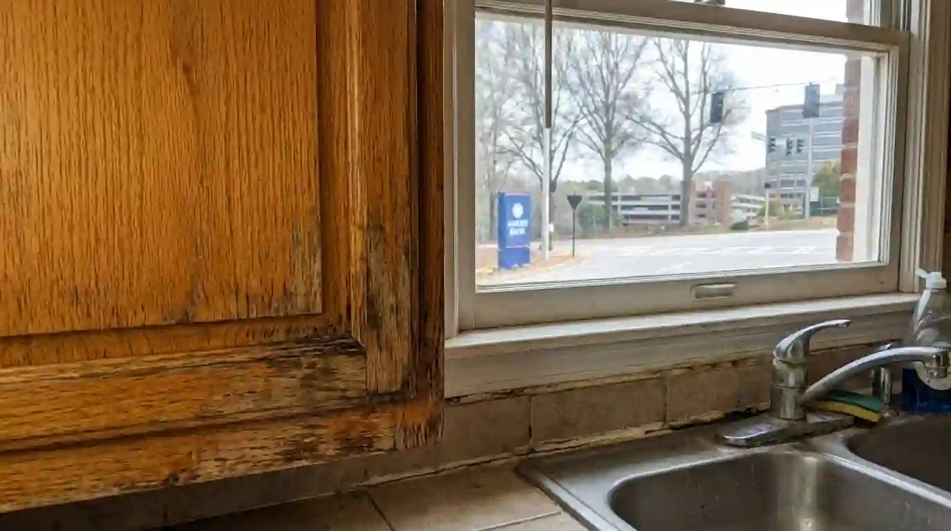 Worn oak cabinet finish beside a kitchen sink
